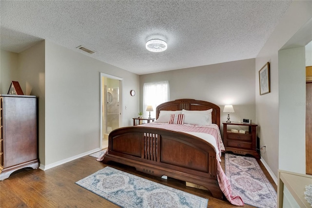 1502 Fort Duquesna Dr, Sun City Center, FL 33573 - bedroom with wood finished floors, a textured ceiling, and ensuite bathroom