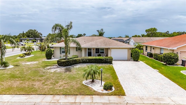 1502 Fort Duquesna Dr, Sun City Center, FL 33573 - ranch-style home with an attached garage, decorative driveway, a front yard, and stucco siding