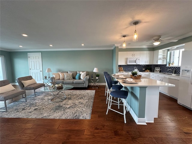 1365 Snell Isle Blvd NE Unit 6E, Saint Petersburg, FL 33704 - kitchen featuring white appliances, white cabinets, light countertops, a breakfast bar, and dark wood-style flooring