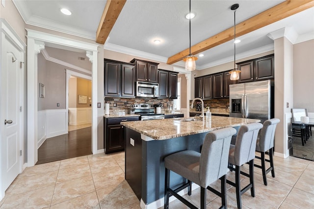 1604 Acadia Harbor Pl, Brandon, FL 33511 - kitchen with appliances with stainless steel finishes, beam ceiling, decorative backsplash, light stone countertops, and a kitchen breakfast bar