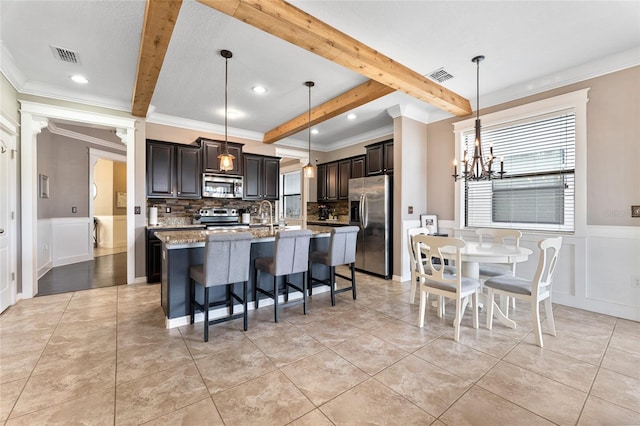 1604 Acadia Harbor Pl, Brandon, FL 33511 - kitchen featuring appliances with stainless steel finishes, beam ceiling, crown molding, tasteful backsplash, and a decorative wall