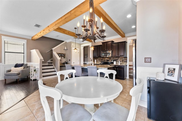 1604 Acadia Harbor Pl, Brandon, FL 33511 - dining room with beam ceiling, stairs, a chandelier, light tile patterned floors, and ornamental molding