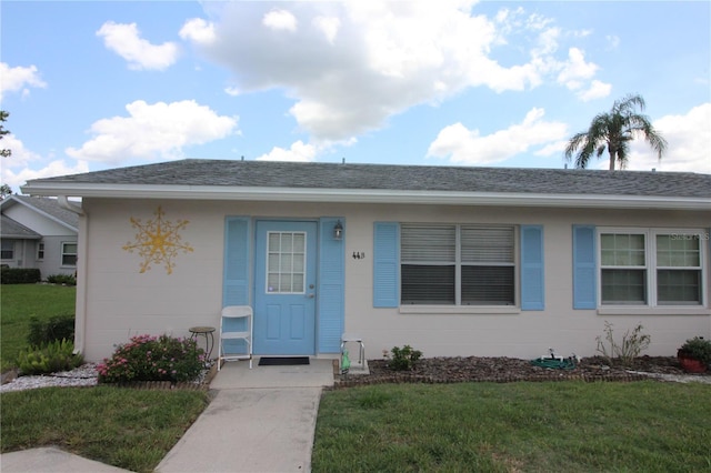 402 Dorchester Pl Unit 44, Sun City Center, FL 33573 - view of front of property featuring concrete block siding, a front lawn, and roof with shingles