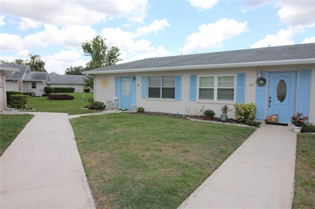 402 Dorchester Pl Unit 44, Sun City Center, FL 33573 - view of front facade with a front yard, a shingled roof, and stucco siding