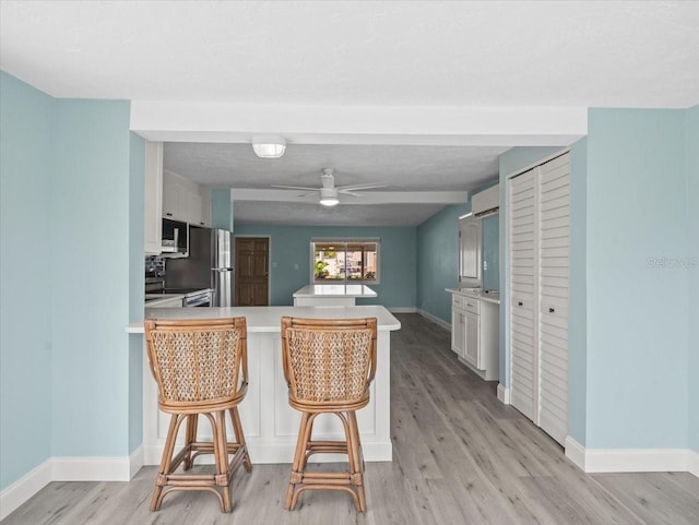 13316 Carol Dr, Hudson, FL 34667 - kitchen featuring a peninsula, light countertops, stainless steel appliances, and light wood-type flooring