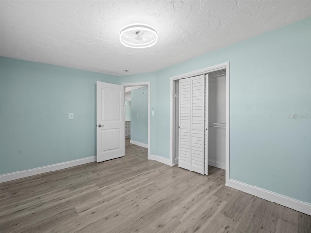 13316 Carol Dr, Hudson, FL 34667 - unfurnished bedroom featuring wood finished floors, a closet, and a textured ceiling