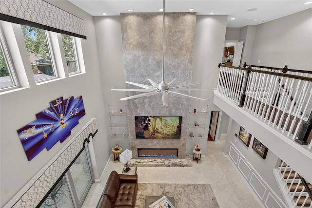 10313 Scarlet Chase Dr, Riverview, FL 33569 - living area with a glass covered fireplace, a ceiling fan, recessed lighting, a towering ceiling, and tile patterned flooring
