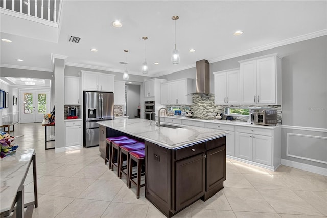 10313 Scarlet Chase Dr, Riverview, FL 33569 - kitchen featuring appliances with stainless steel finishes, wall chimney exhaust hood, tasteful backsplash, a kitchen breakfast bar, and white cabinetry