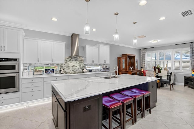 10313 Scarlet Chase Dr, Riverview, FL 33569 - kitchen with wall chimney range hood, light tile patterned floors, crown molding, double oven, and backsplash
