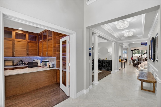 10313 Scarlet Chase Dr, Riverview, FL 33569 - hallway featuring decorative columns, crown molding, a chandelier, light tile patterned floors, and a tray ceiling