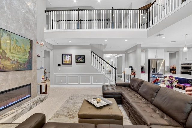 10313 Scarlet Chase Dr, Riverview, FL 33569 - living area with a towering ceiling, a decorative wall, stairs, ornamental molding, and recessed lighting