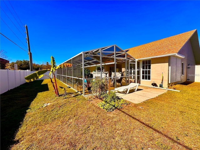 8616 Pinafore Dr, New Port Richey, FL 34653 - rear view of property featuring a fenced backyard, stucco siding, a patio, a lanai, and a shingled roof