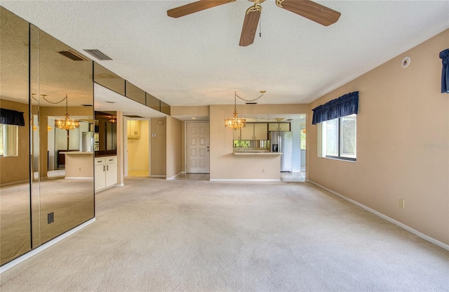 700 Starkey Rd Unit 1145, Largo, FL 33771 - unfurnished living room featuring a chandelier, light colored carpet, ceiling fan, and a textured ceiling