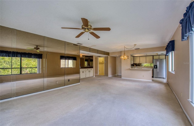 700 Starkey Rd Unit 1145, Largo, FL 33771 - unfurnished living room with ceiling fan, light colored carpet, and a chandelier