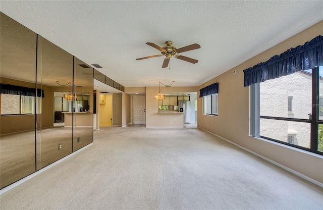 700 Starkey Rd Unit 1145, Largo, FL 33771 - unfurnished living room with a chandelier, a ceiling fan, light colored carpet, and a textured ceiling