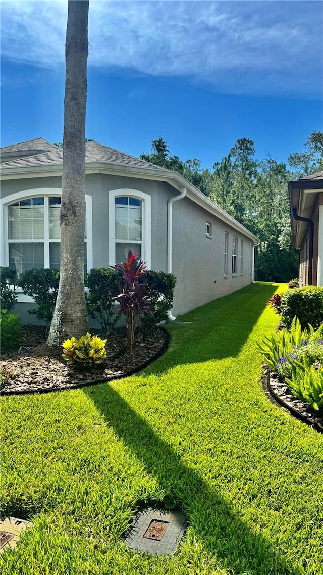 27312 Edenfield Dr, Wesley Chapel, FL 33544 - view of property exterior with stucco siding and a lawn