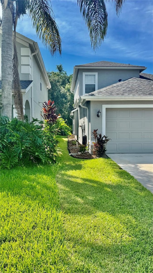 27312 Edenfield Dr, Wesley Chapel, FL 33544 - view of front of house featuring stucco siding, a garage, a front lawn, and driveway