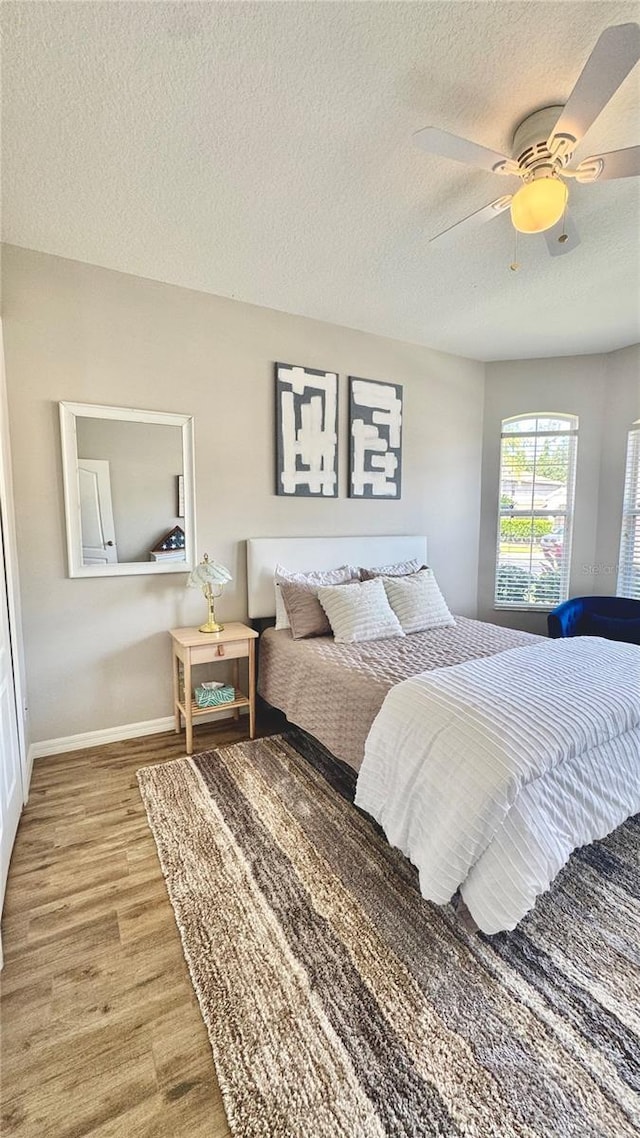 27312 Edenfield Dr, Wesley Chapel, FL 33544 - bedroom featuring wood finished floors, a textured ceiling, and ceiling fan