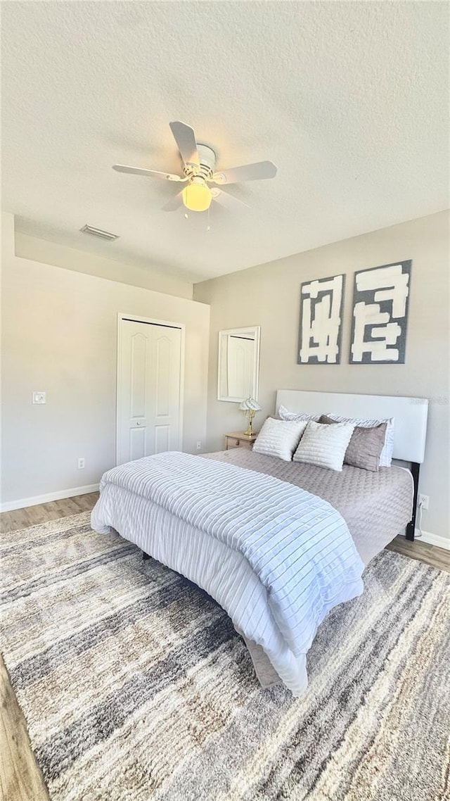 27312 Edenfield Dr, Wesley Chapel, FL 33544 - bedroom featuring a textured ceiling, ceiling fan, a closet, and wood finished floors