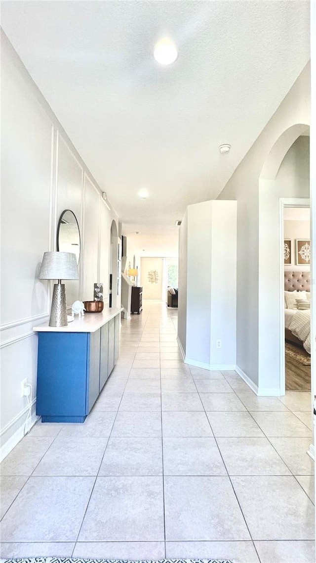 27312 Edenfield Dr, Wesley Chapel, FL 33544 - hallway with light tile patterned flooring and arched walkways