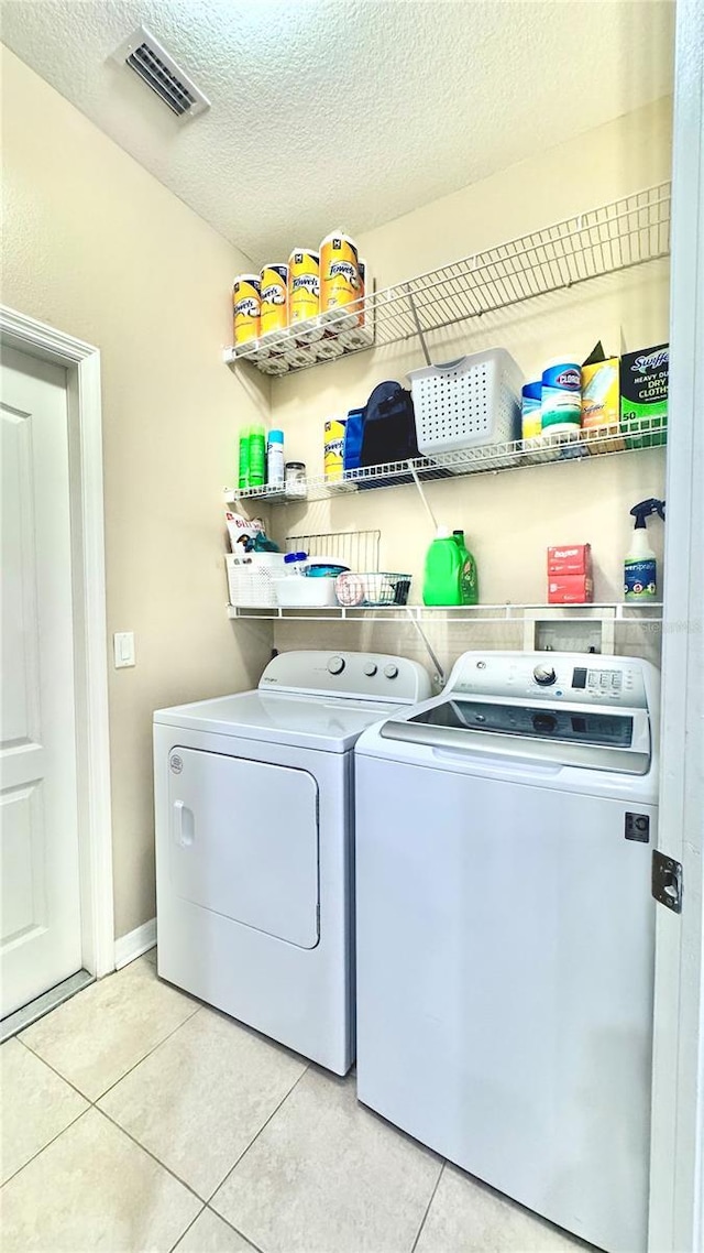 27312 Edenfield Dr, Wesley Chapel, FL 33544 - laundry area featuring independent washer and dryer, light tile patterned floors, and a textured ceiling