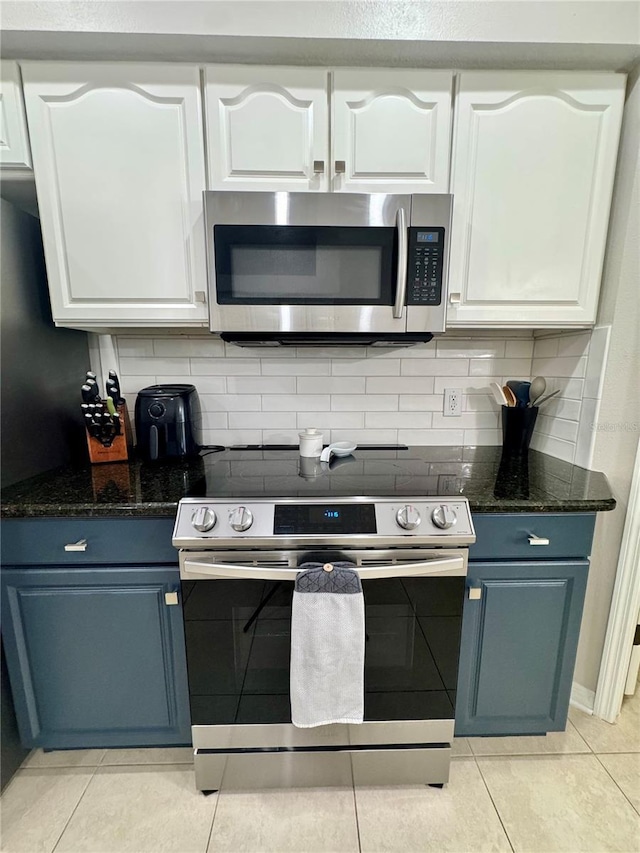 27312 Edenfield Dr, Wesley Chapel, FL 33544 - kitchen featuring stainless steel appliances, white cabinetry, light tile patterned floors, and blue cabinetry