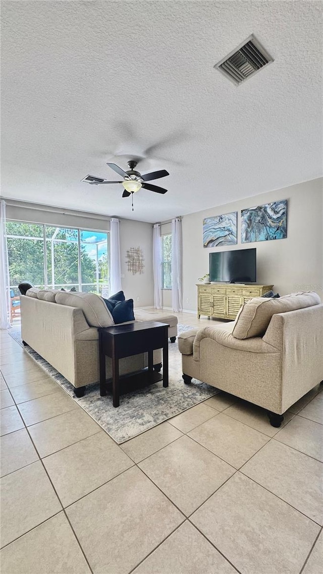 27312 Edenfield Dr, Wesley Chapel, FL 33544 - living area featuring light tile patterned floors, ceiling fan, and a textured ceiling