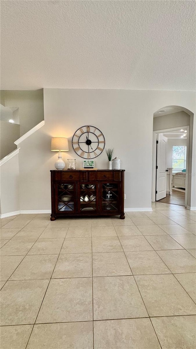 27312 Edenfield Dr, Wesley Chapel, FL 33544 - corridor with arched walkways, light tile patterned floors, and a textured ceiling