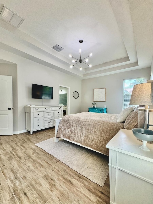 27312 Edenfield Dr, Wesley Chapel, FL 33544 - bedroom with a raised ceiling, a chandelier, and light wood-style flooring