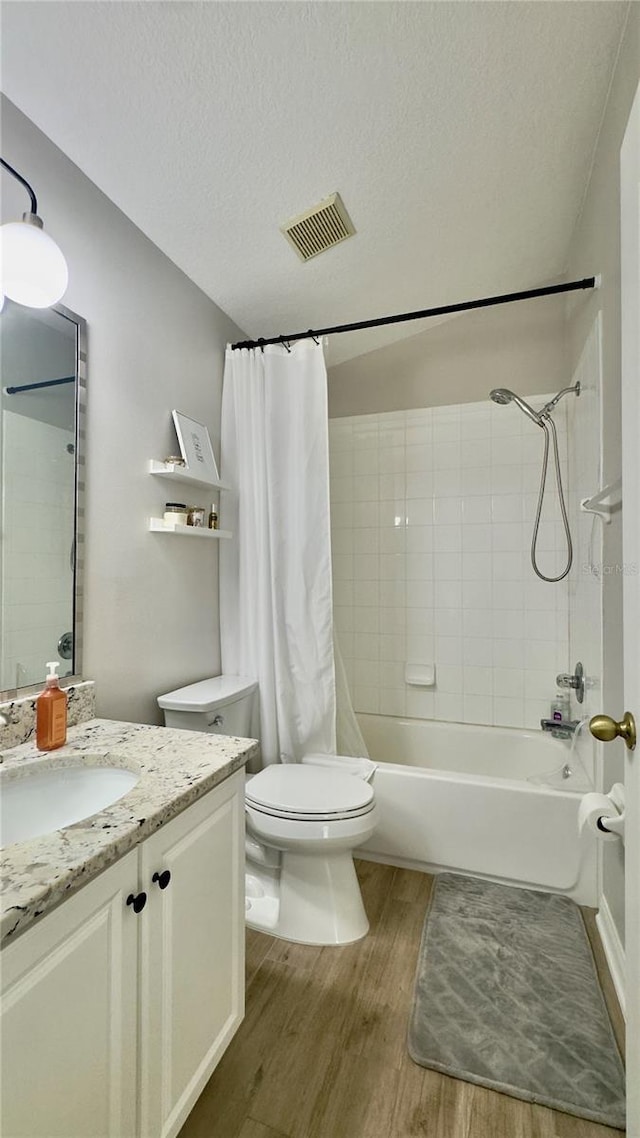 27312 Edenfield Dr, Wesley Chapel, FL 33544 - bathroom with wood finished floors, vanity, shower / bathtub combination with curtain, and a textured ceiling