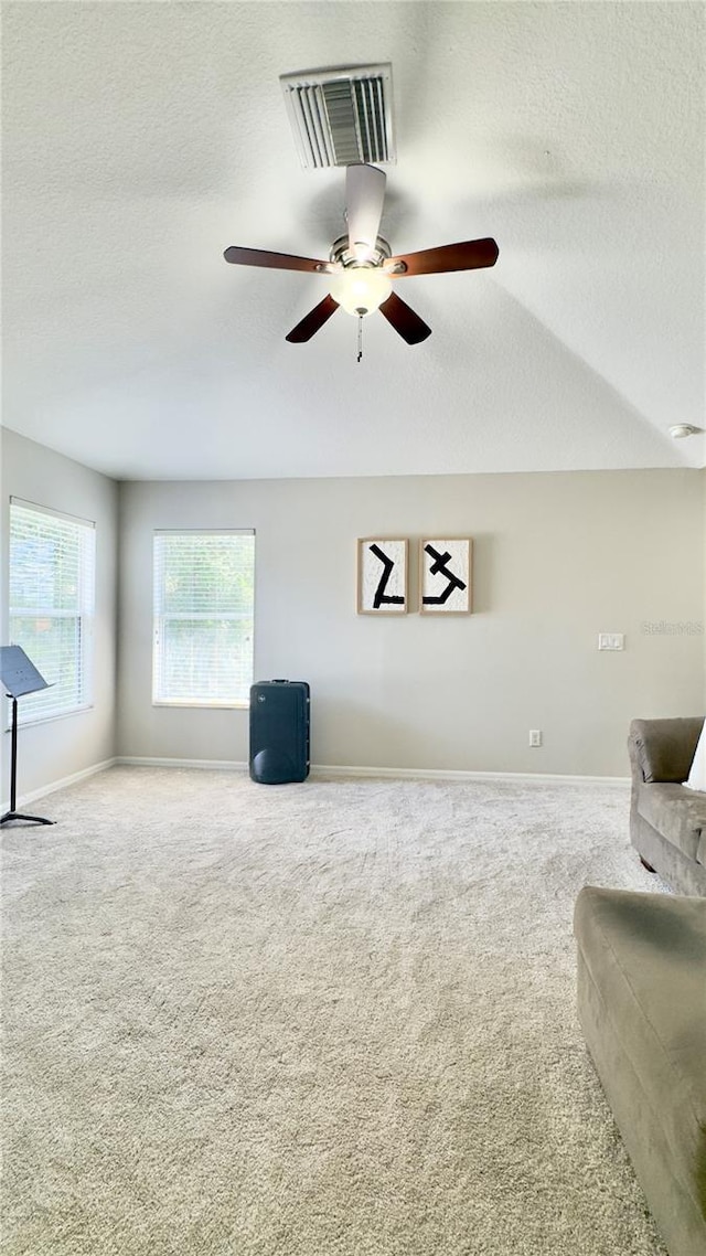 27312 Edenfield Dr, Wesley Chapel, FL 33544 - unfurnished living room with a textured ceiling, carpet flooring, and a ceiling fan