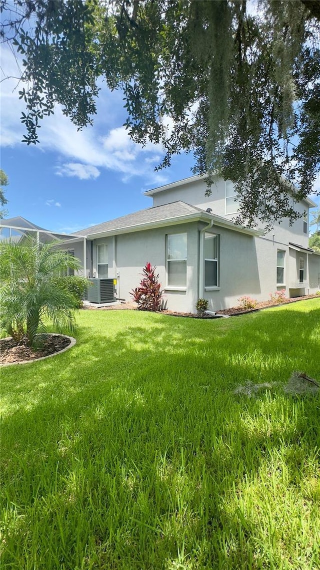 27312 Edenfield Dr, Wesley Chapel, FL 33544 - rear view of house with stucco siding and a lawn