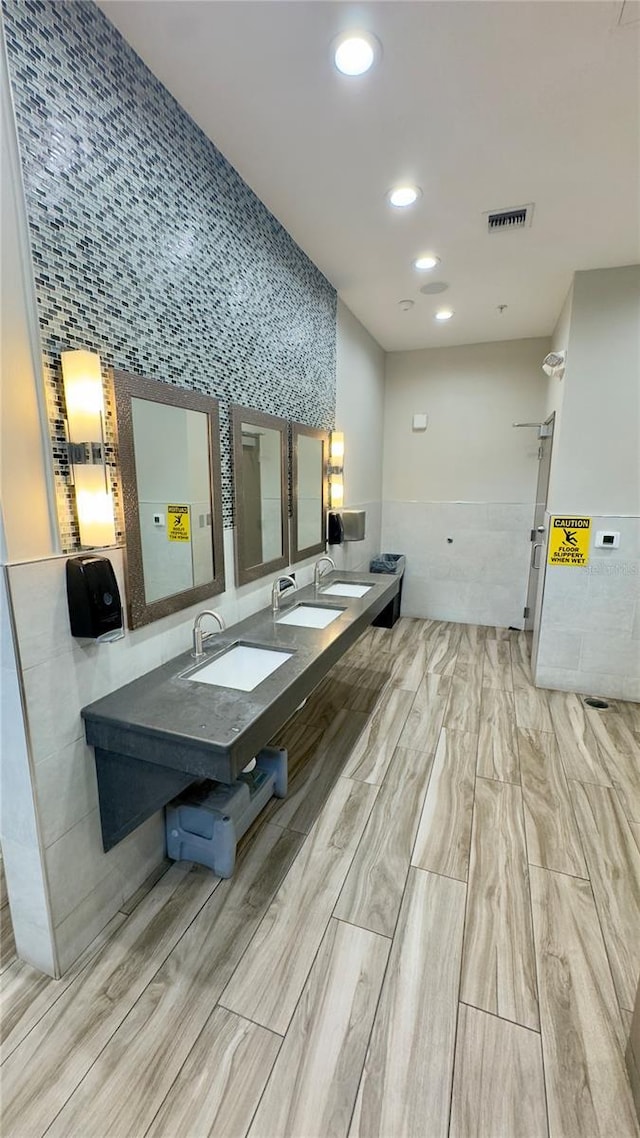 27312 Edenfield Dr, Wesley Chapel, FL 33544 - full bathroom featuring tile walls, wood finished floors, recessed lighting, and double vanity
