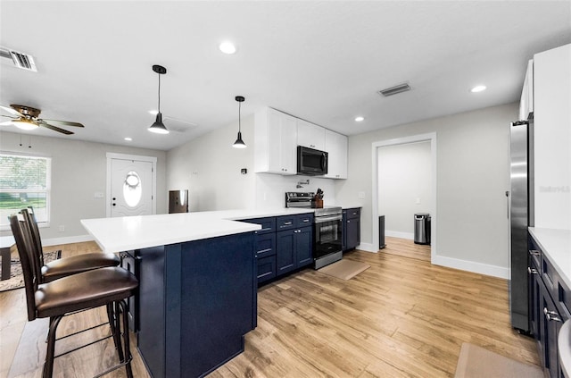 1800 Mapleleaf Blvd, Oldsmar, FL 34677 - kitchen featuring appliances with stainless steel finishes, a peninsula, white cabinets, light wood-style flooring, and a kitchen bar