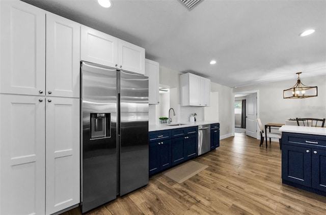 1800 Mapleleaf Blvd, Oldsmar, FL 34677 - kitchen featuring stainless steel appliances, blue cabinets, light countertops, recessed lighting, and white cabinets