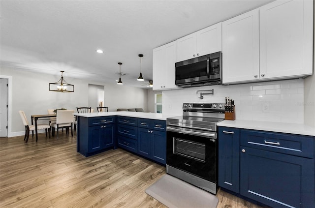 1800 Mapleleaf Blvd, Oldsmar, FL 34677 - kitchen with electric stove, blue cabinetry, a peninsula, light countertops, and white cabinets