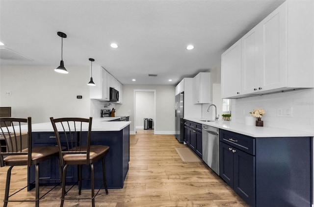 1800 Mapleleaf Blvd, Oldsmar, FL 34677 - kitchen featuring stainless steel appliances, a breakfast bar area, light wood-style floors, recessed lighting, and light countertops