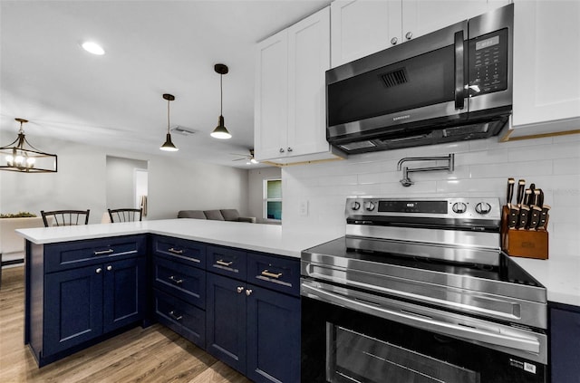 1800 Mapleleaf Blvd, Oldsmar, FL 34677 - kitchen featuring appliances with stainless steel finishes, blue cabinetry, open floor plan, and white cabinetry