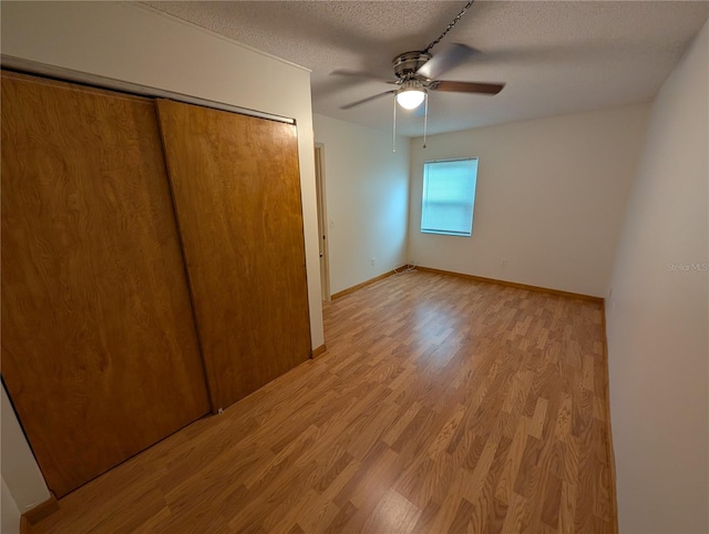 11308 Echo View Dr, Odessa, FL 33556 - unfurnished bedroom with a textured ceiling, light wood-type flooring, a closet, and ceiling fan