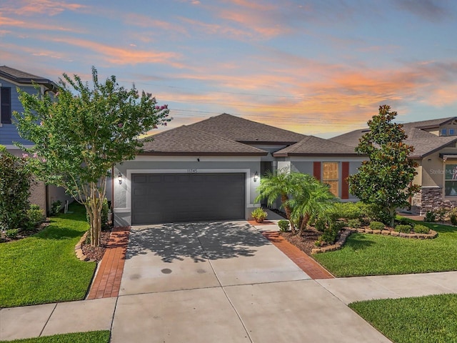11745 Brighton Knoll Loop, Riverview, FL 33579 - view of front of property featuring a garage, concrete driveway, a lawn, and stucco siding
