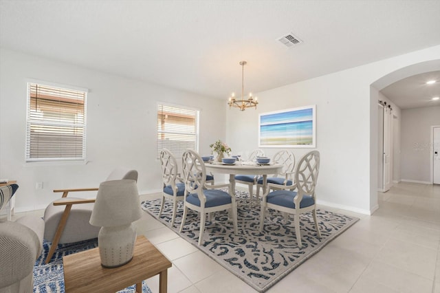 11745 Brighton Knoll Loop, Riverview, FL 33579 - dining room with arched walkways, light tile patterned floors, and a chandelier