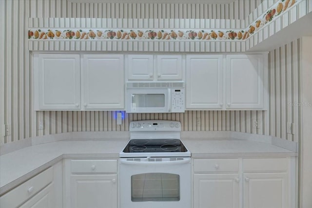 1216 Fox Chapel Dr, Lutz, FL 33549 - kitchen with white appliances, wallpapered walls, light countertops, and white cabinetry