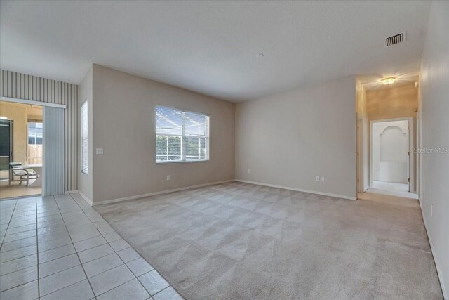 1216 Fox Chapel Dr, Lutz, FL 33549 - unfurnished room with healthy amount of natural light, light colored carpet, and light tile patterned flooring