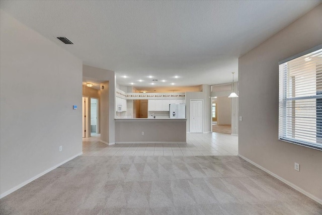 1216 Fox Chapel Dr, Lutz, FL 33549 - unfurnished living room with light carpet, light tile patterned flooring, and a textured ceiling