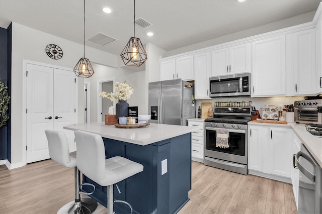 6352 Mooring Line Cir, Apollo Beach, FL 33572 - kitchen with stainless steel appliances, light wood finished floors, white cabinets, and recessed lighting