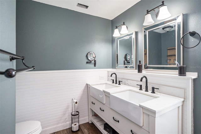 2701 Herndon St, Valrico, FL 33596 - bathroom with wood finished floors, double vanity, and wainscoting