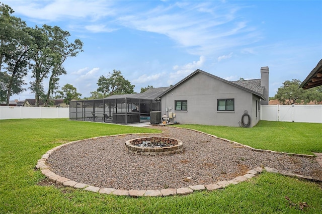 2701 Herndon St, Valrico, FL 33596 - rear view of house with a fenced backyard, a lanai, stucco siding, an outdoor fire pit, and a chimney