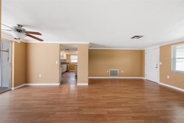 5720 Mockingbird Dr, New Port Richey, FL 34652 - unfurnished living room with light wood-type flooring, ornamental molding, and ceiling fan