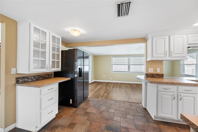 5720 Mockingbird Dr, New Port Richey, FL 34652 - kitchen featuring refrigerator with ice dispenser, glass insert cabinets, white cabinetry, and dark stone finish floors