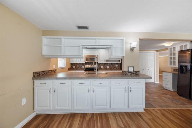5720 Mockingbird Dr, New Port Richey, FL 34652 - kitchen featuring open shelves, fridge with ice dispenser, stainless steel microwave, and decorative backsplash